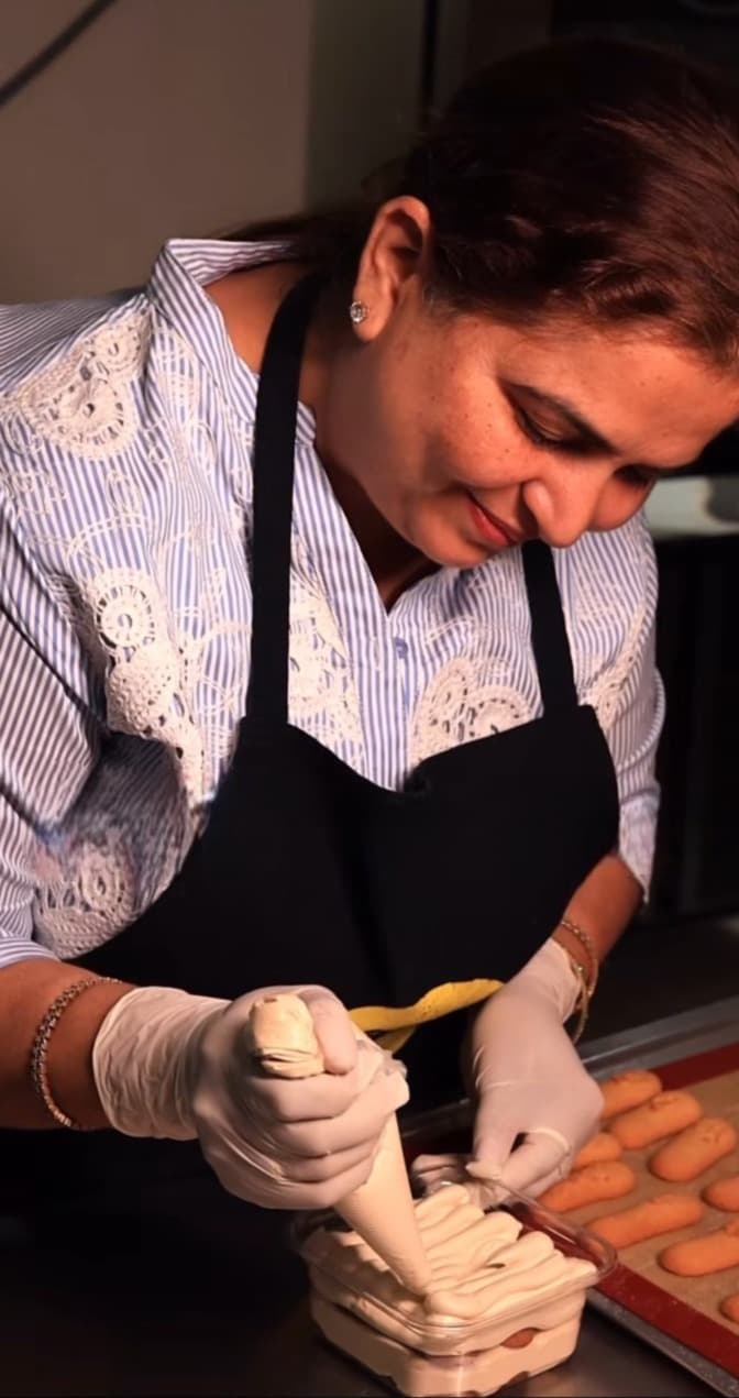 Founder of One Sweet Day carefully piping pastries by hand.
